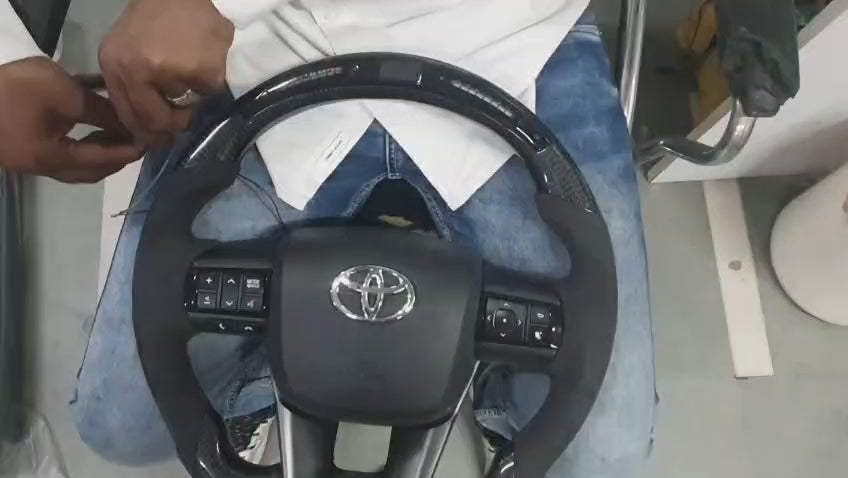 
                  
                    Load and play video in Gallery viewer, real carbon fibre steering wheel with LED alcantara for Toyota Fortuner / Crysta / Hilux
                  
                